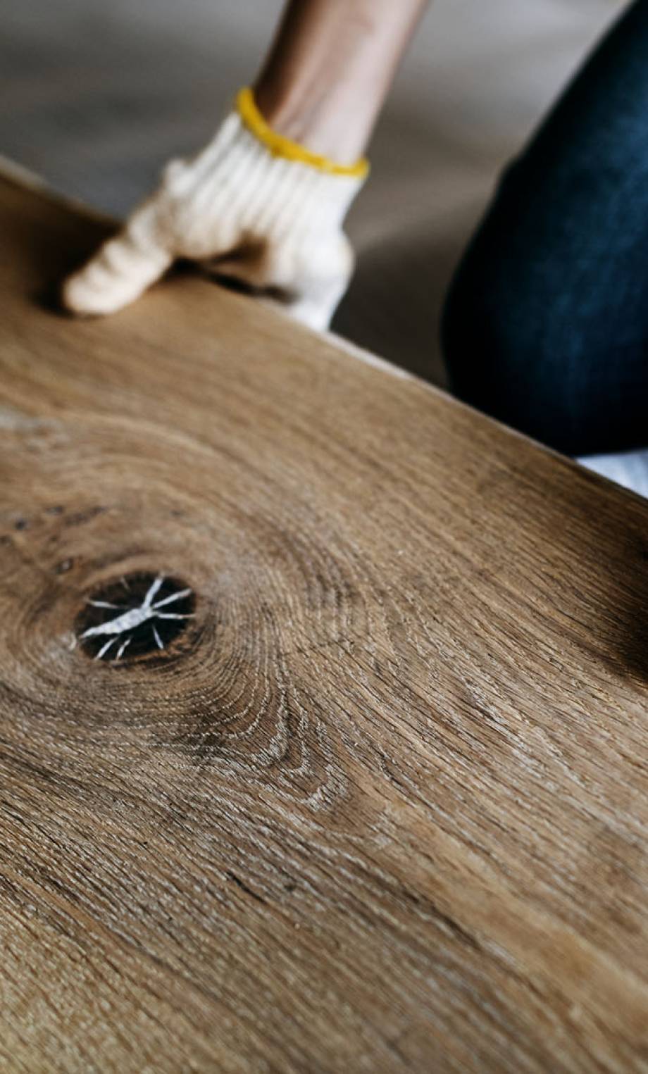 a person wearing gloves on a wood surface